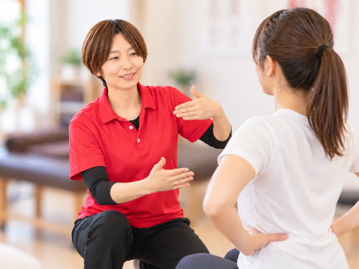 女性整体師がお客様へセルフケアの方法を説明する様子
